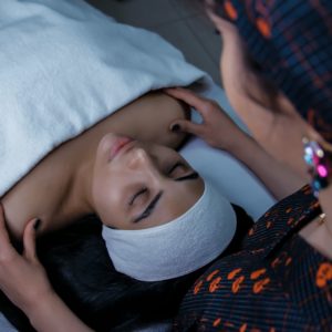 a woman laying in bed with a towel on her head